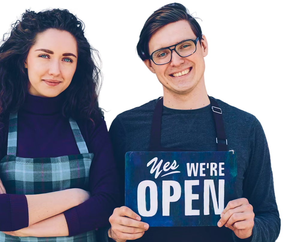 Local small-business owners holding a “Yes we're open” sign